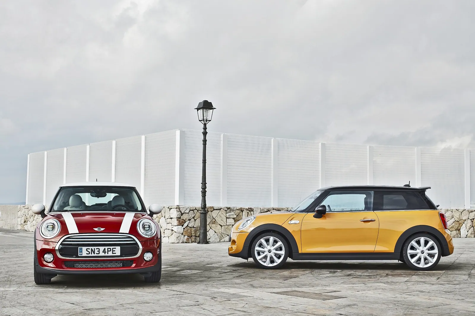 海辺に並ぶ赤と黄色の第3世代MINI Cooper